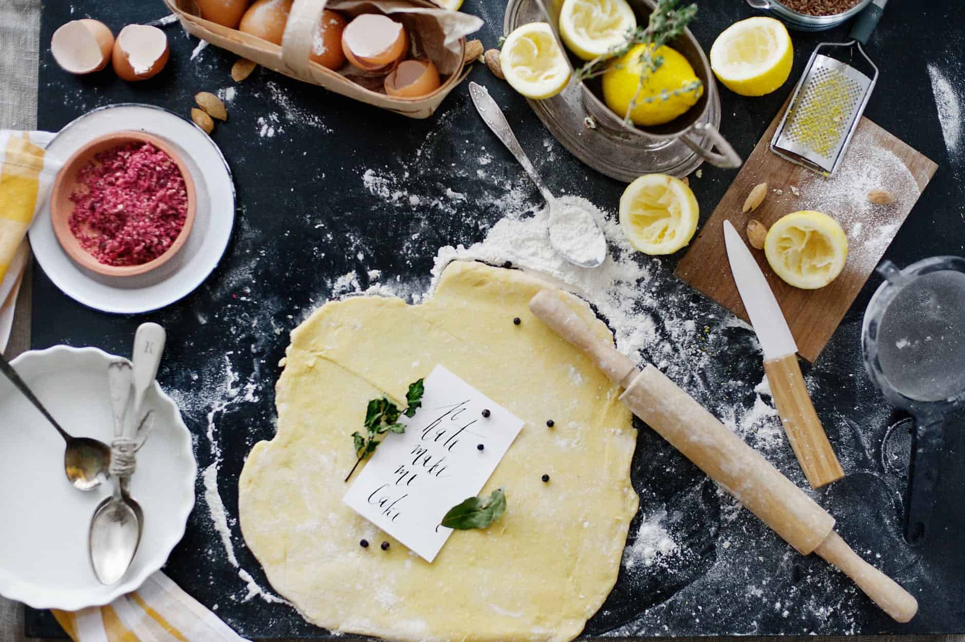 dough and flour near lemons and rolling pin